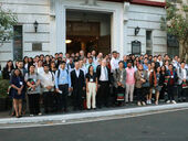Conference participants standing in a group by the entrance to a building.