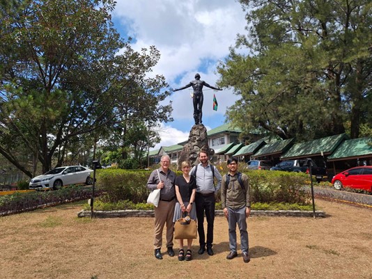 Four of the projects researchers standing in front of a statue.